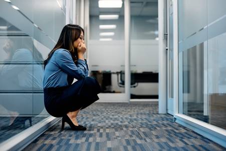 Woman sitting outside of cubicle - FMLA Retaliation